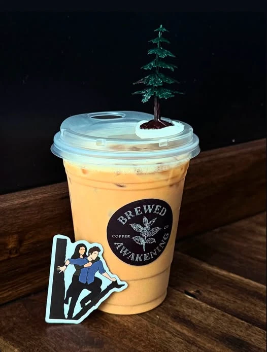 An iced Brewed Awakening drink with a tiny tree decoration, photographed by the shop