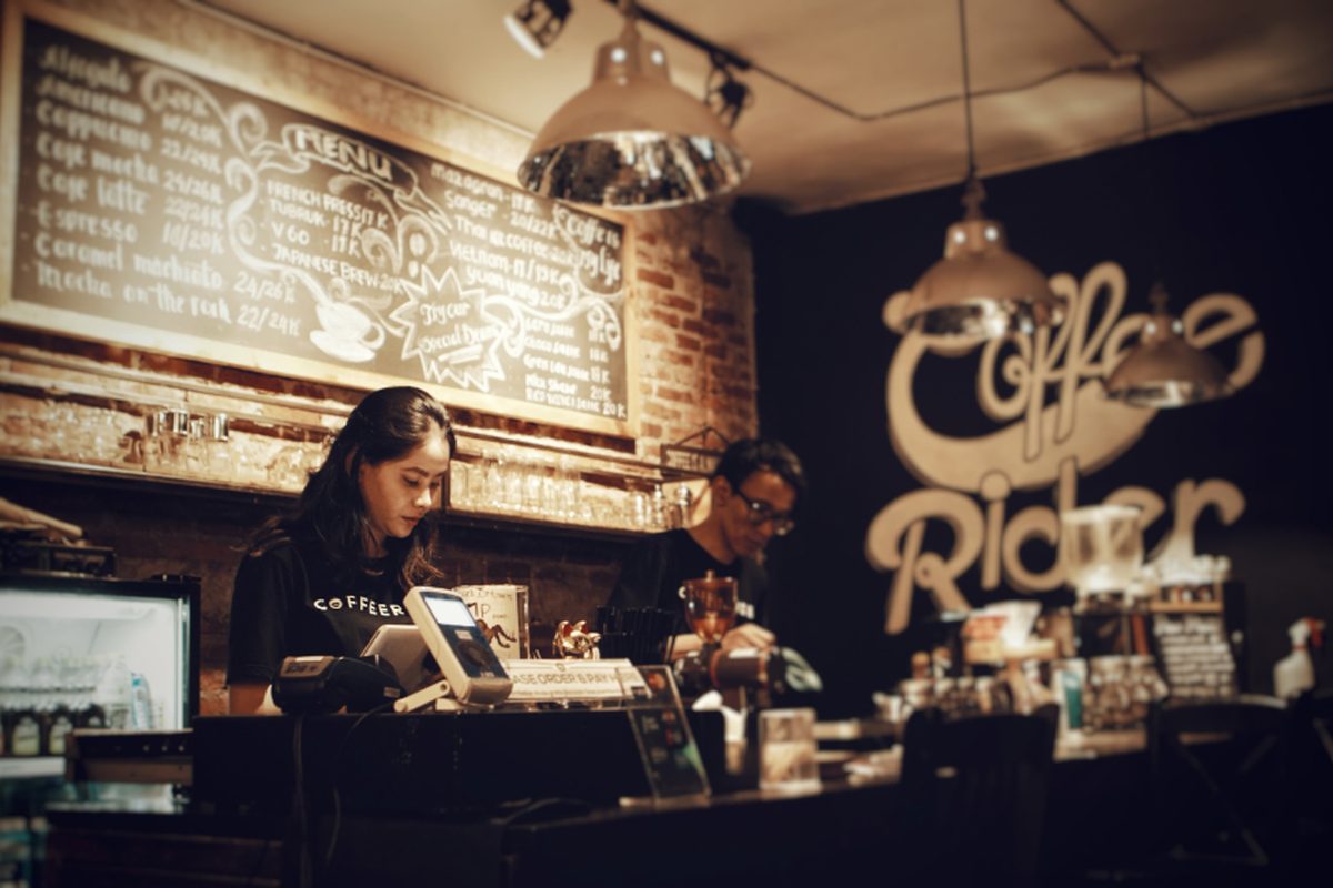 Baristas working behind the brick counter