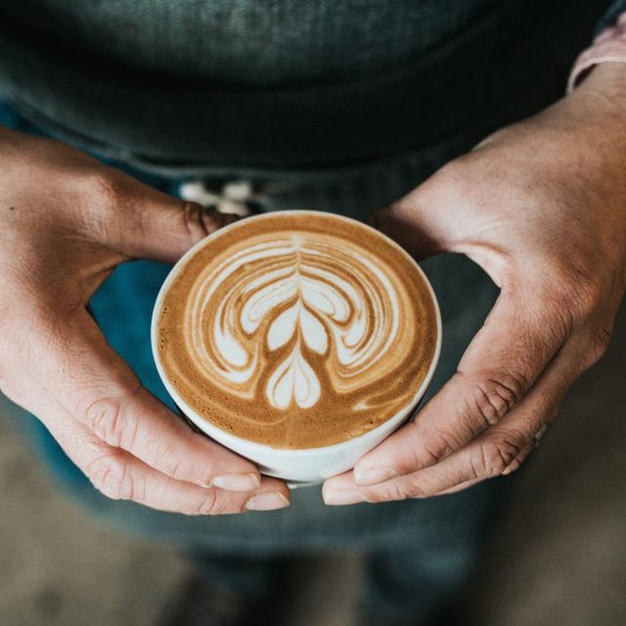Hands cradling a warm cup of coffee